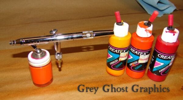Airbrush show with bottles of airbrush paints.