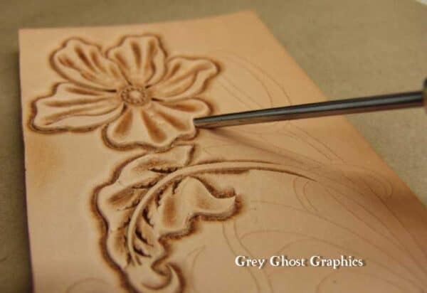 Petal lifter inserted into interior curve of flower petal.