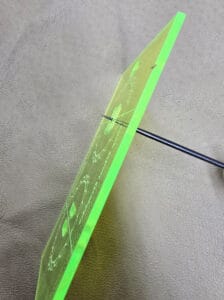 Photo of scratch awl inserted into hole in acrylic template