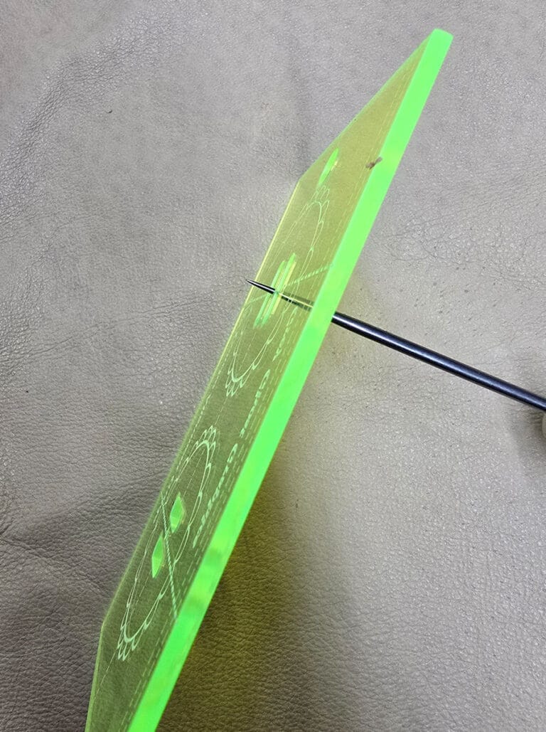 Photo of scratch awl inserted into hole in acrylic template